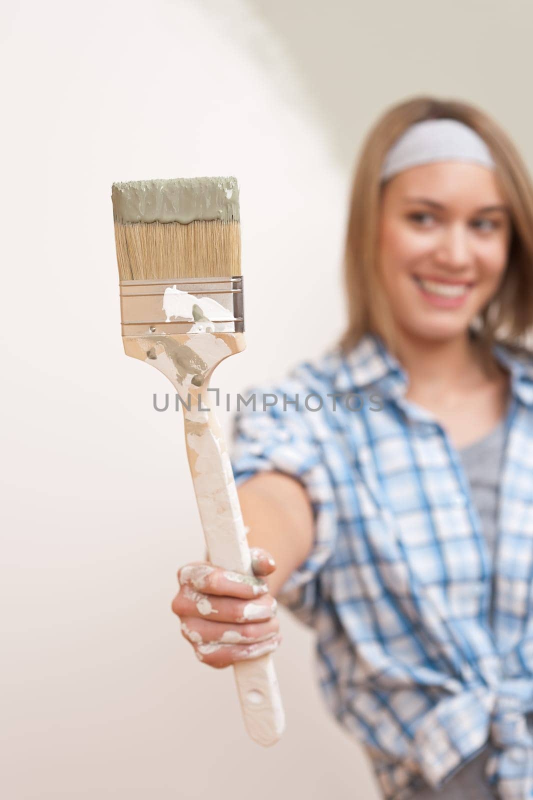 Home improvement: Young woman with paint brush, focus on hand