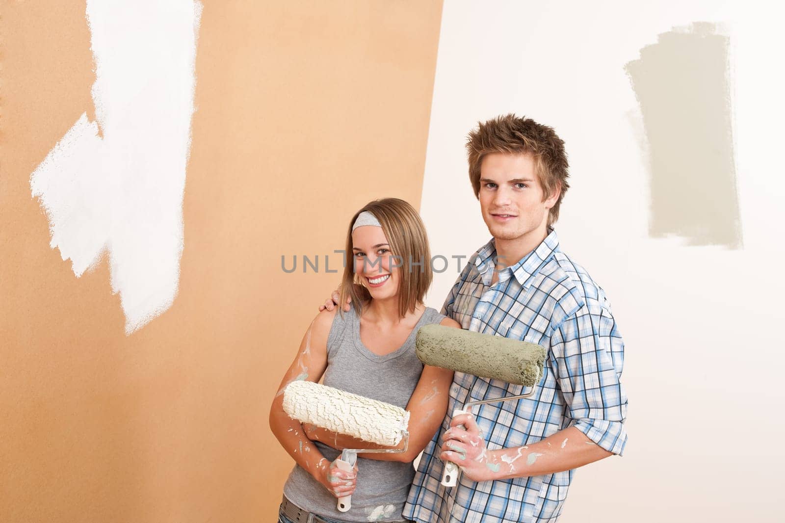 Home improvement: Young man and woman painting wall with paint roller