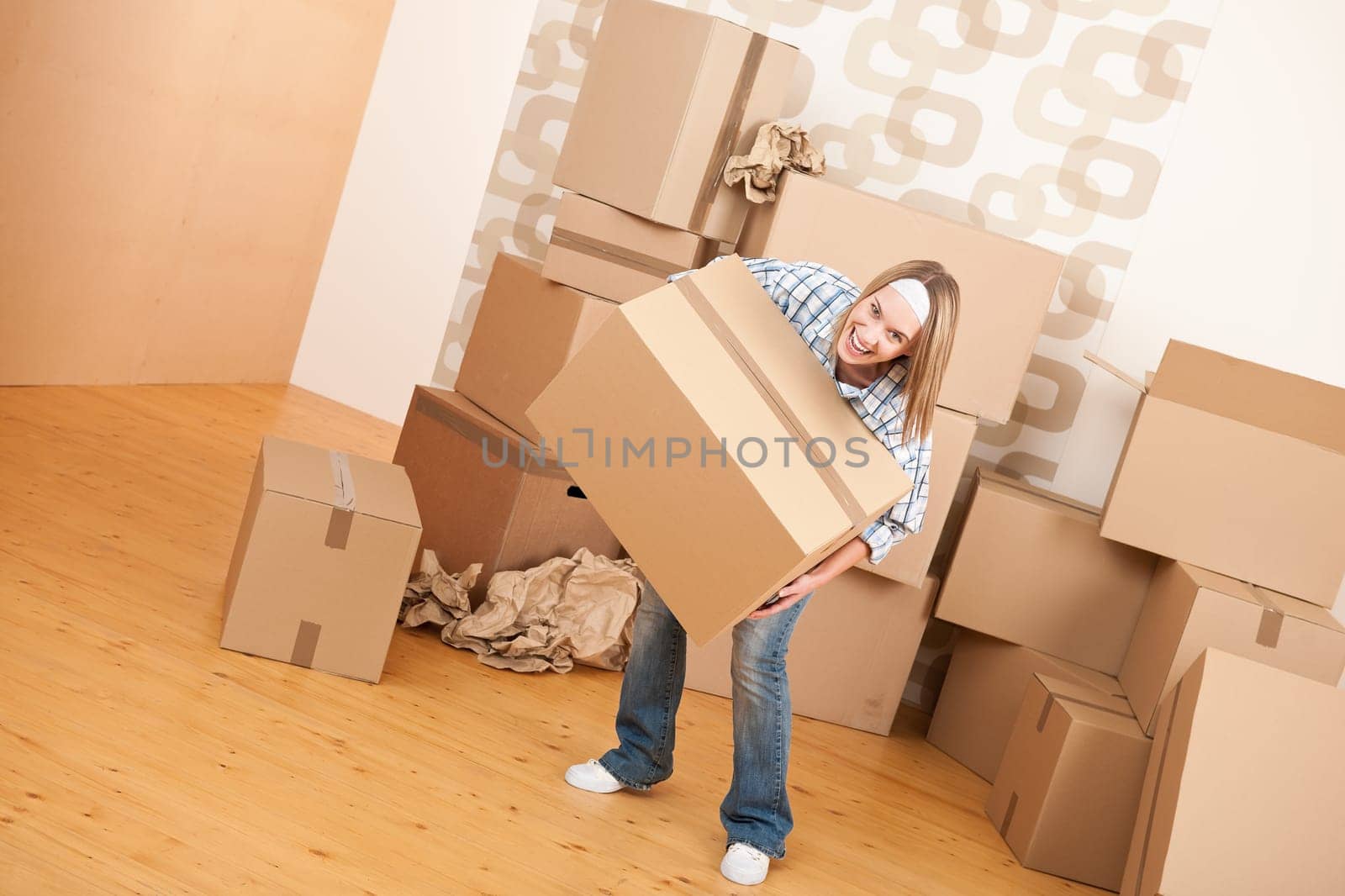 Moving house: Woman holding big carton box in new home