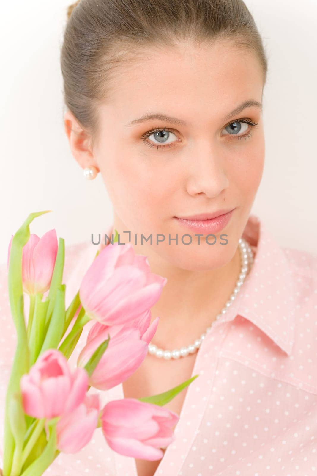 Fashion - young romantic woman with spring tulips in designer clothes