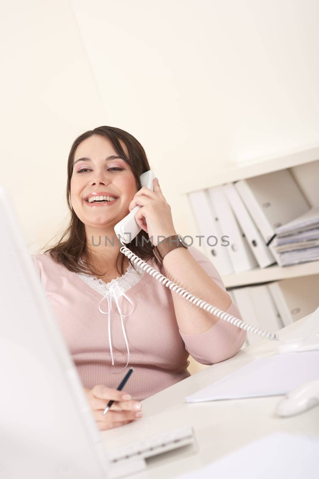 Smiling happy business woman talking on the phone at office