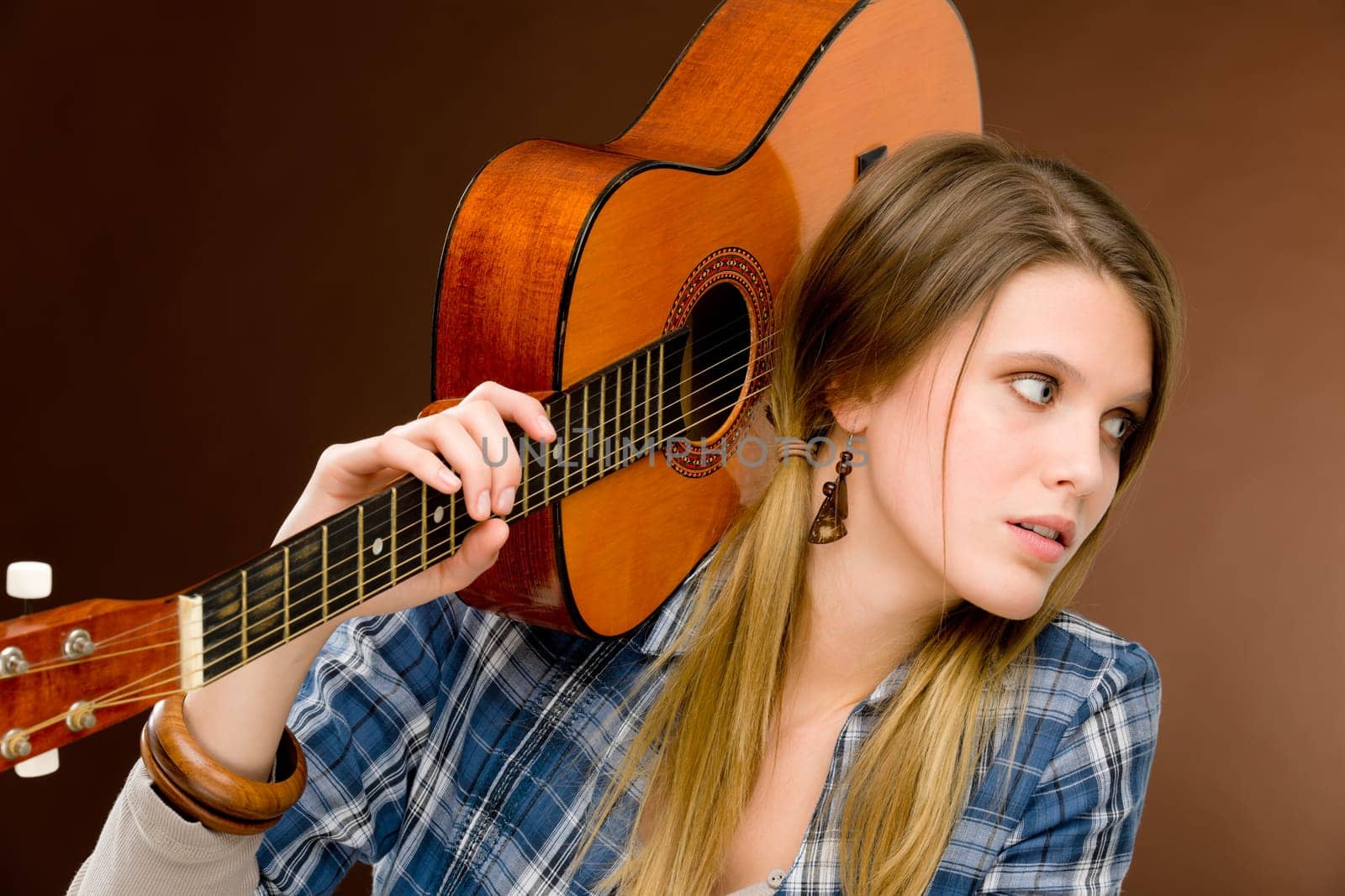 Rock musician - young fashion female model posing with guitar