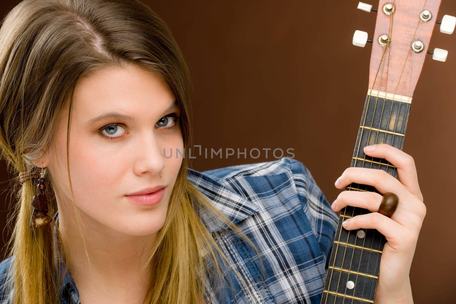 Rock musician - young fashion female model posing with guitar