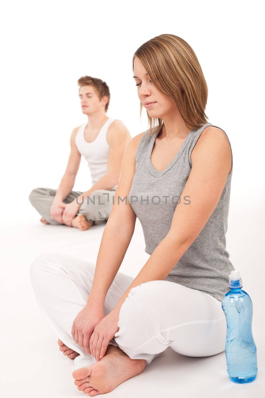 Fitness - Healthy couple stretching after training on white background