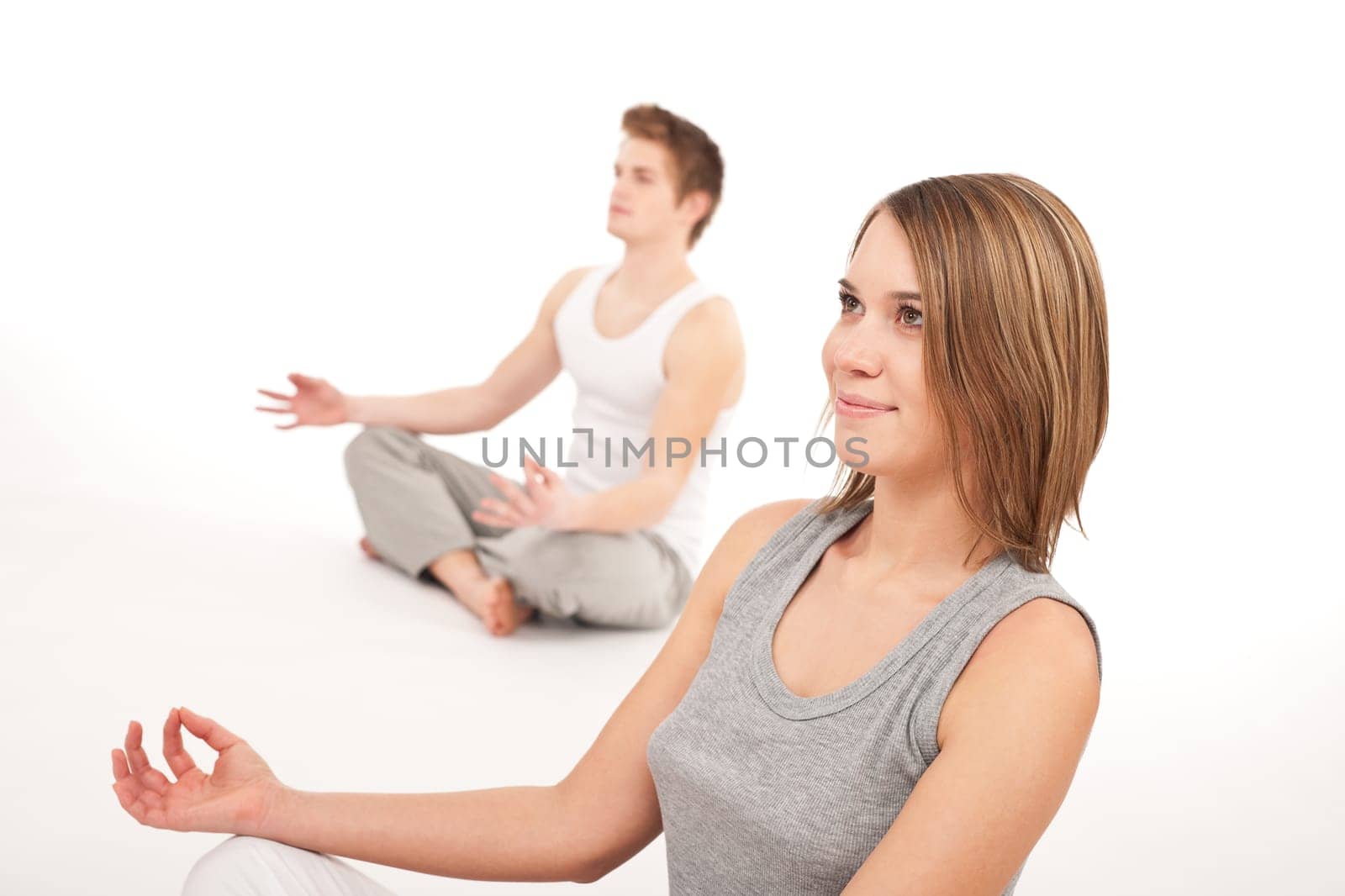 Fitness - Young healthy couple in yoga position on white background