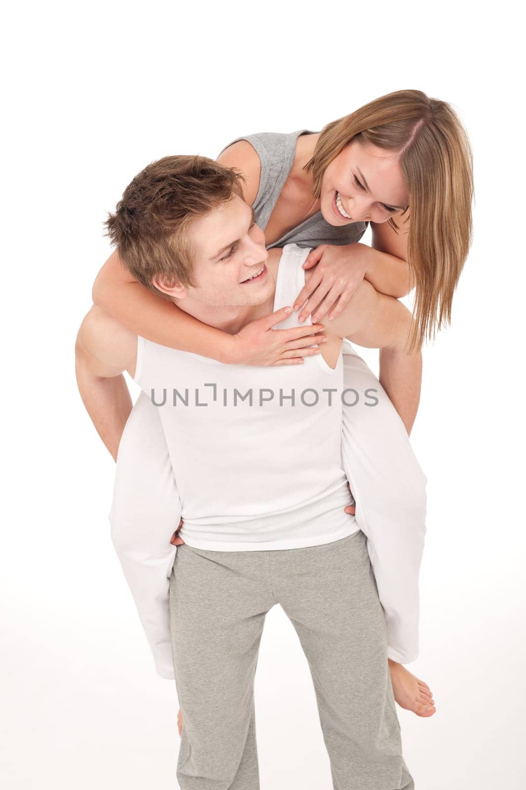 Piggyback - Young sportive smiling couple wearing fitness clothes on white background