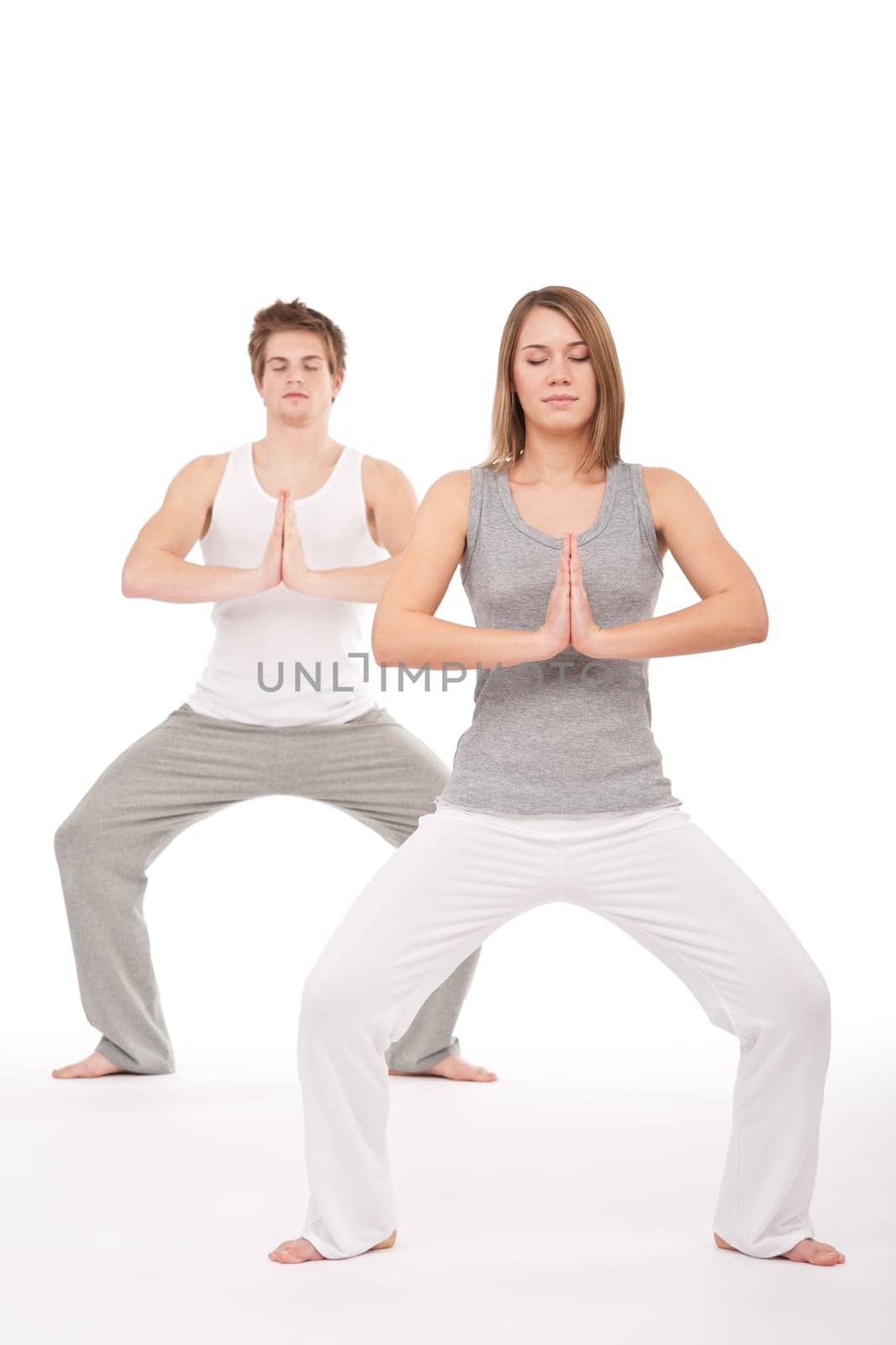 Fitness - Young healthy couple in yoga position on white background
