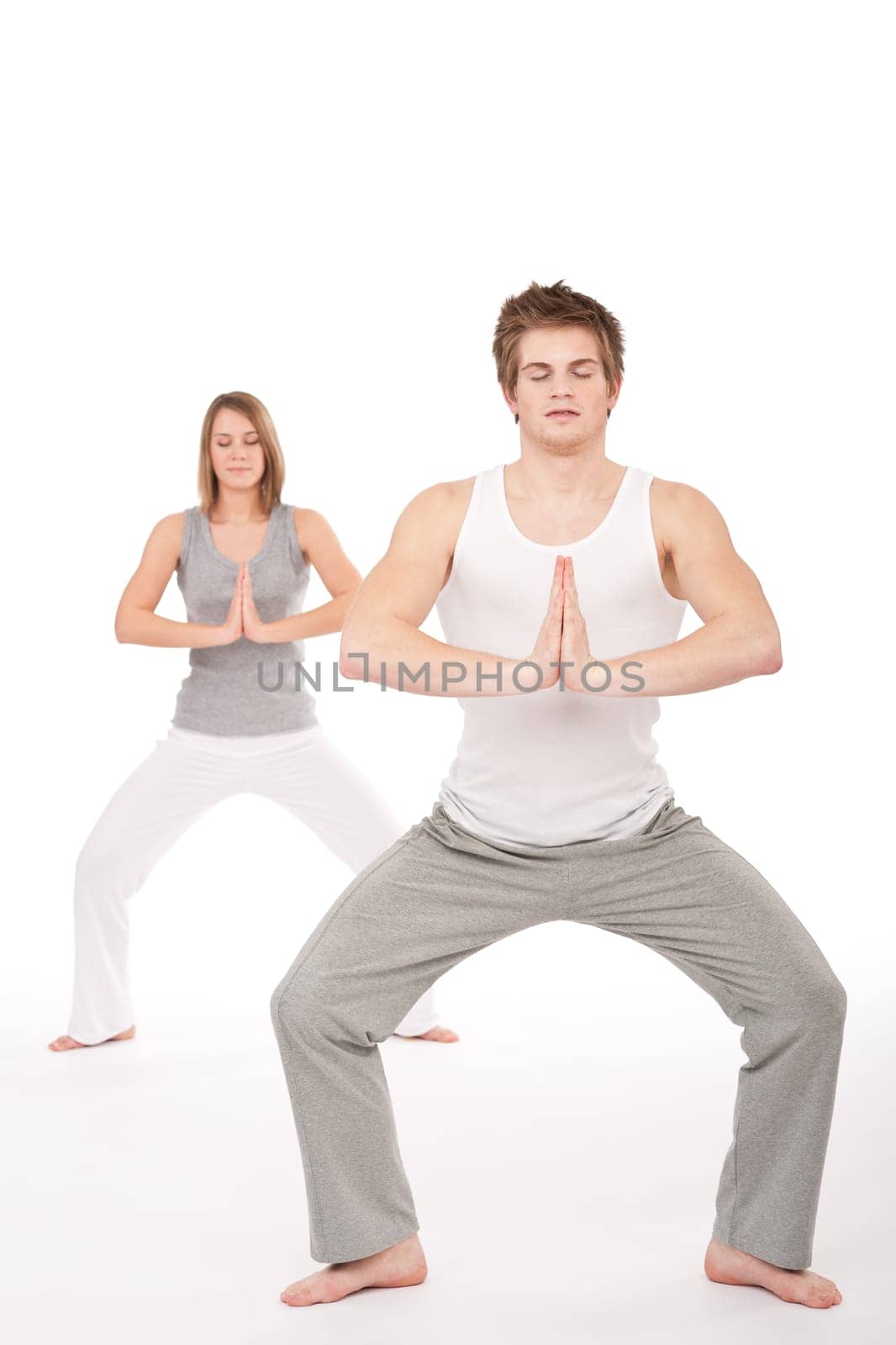 Fitness - Young healthy couple in yoga position on white background