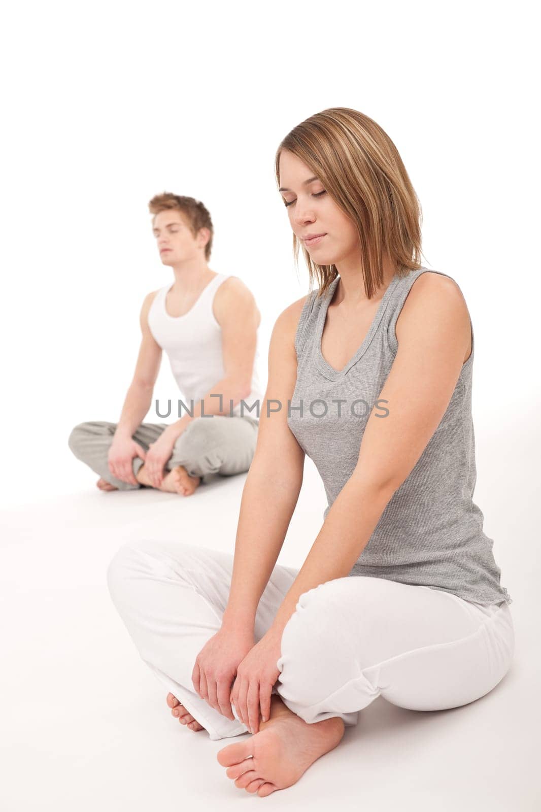 Fitness - Healthy couple stretching after training on white background