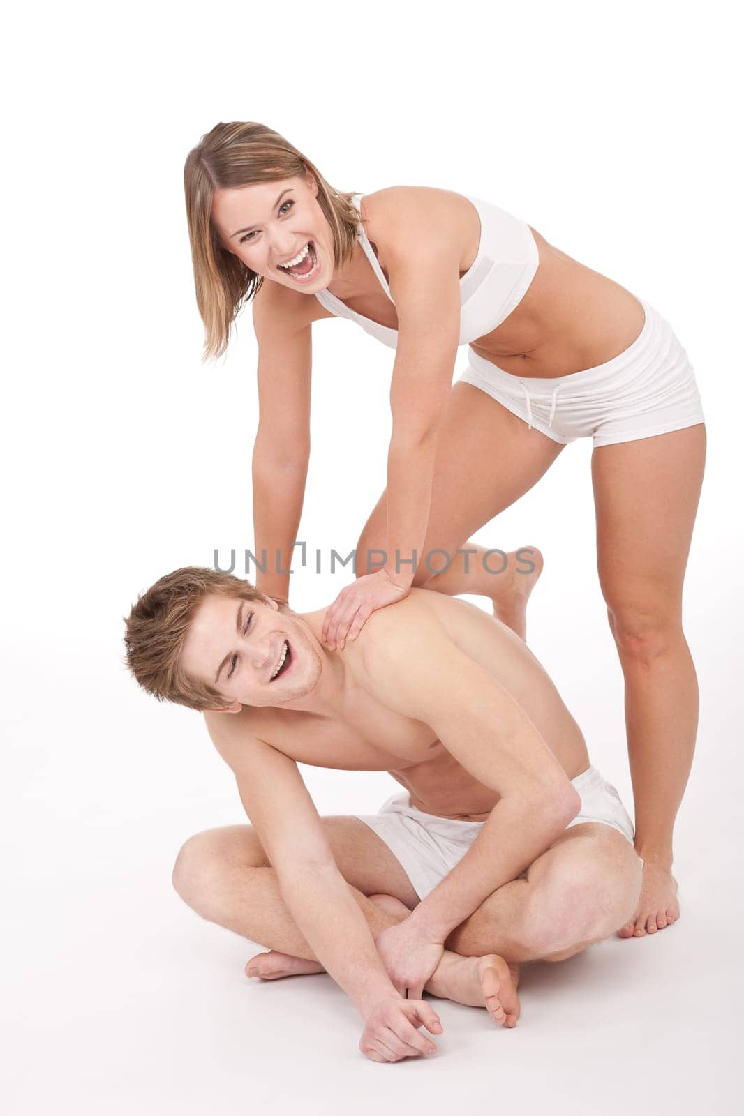 Fitness - Young sportive smiling couple having fun after training on white background