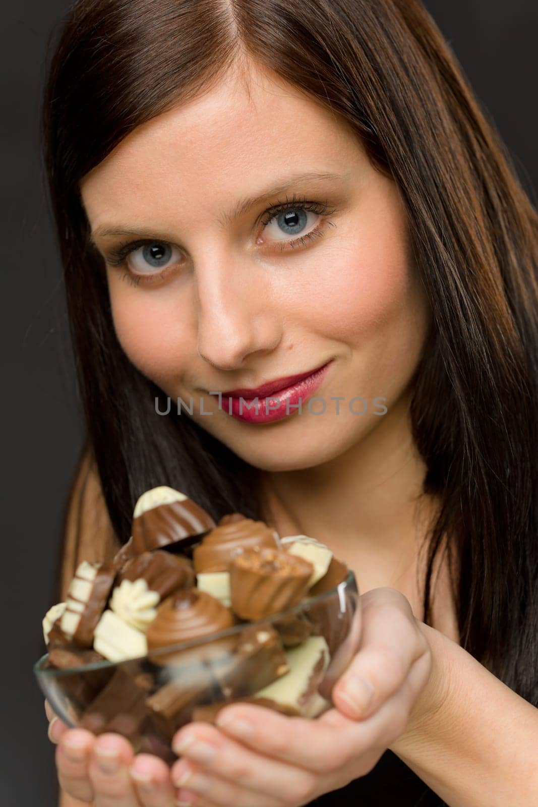 Chocolate - portrait of young woman hold candy in bowl