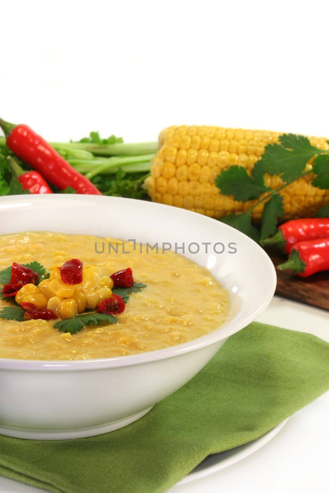a bowl of corn soup with chili and coriander