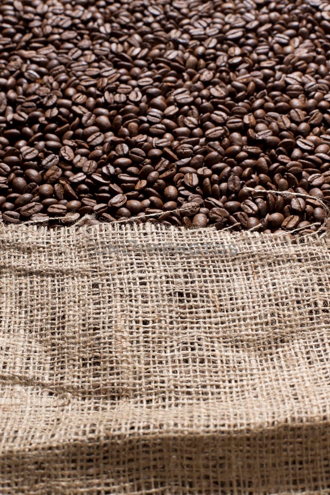 Freshly roasted coffee beans in a large canvas bag