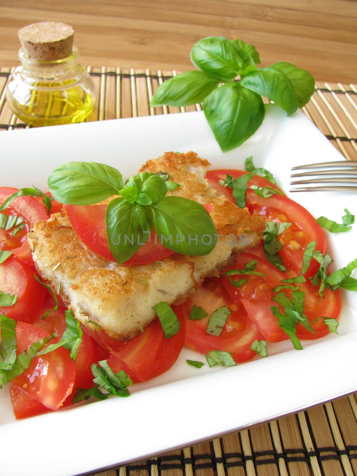 Fish on tomatoes with basil