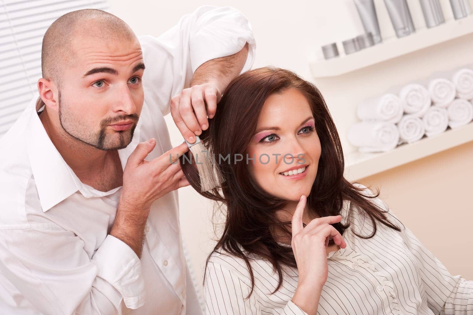 Professional male hairdresser choose hair dye color at modern salon, female customer change hair color