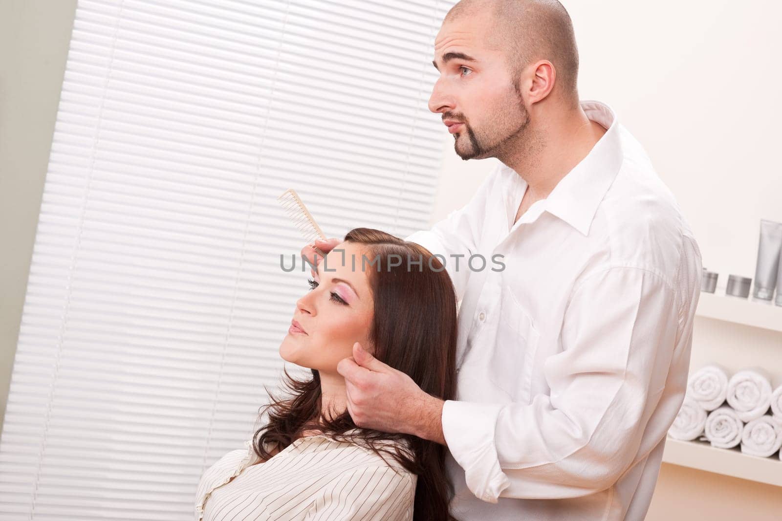 Professional male hairdresser comb female customer at salon