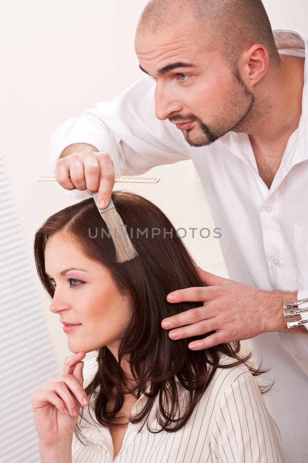 Professional male hairdresser choose hair dye color at modern salon, female customer change hair color