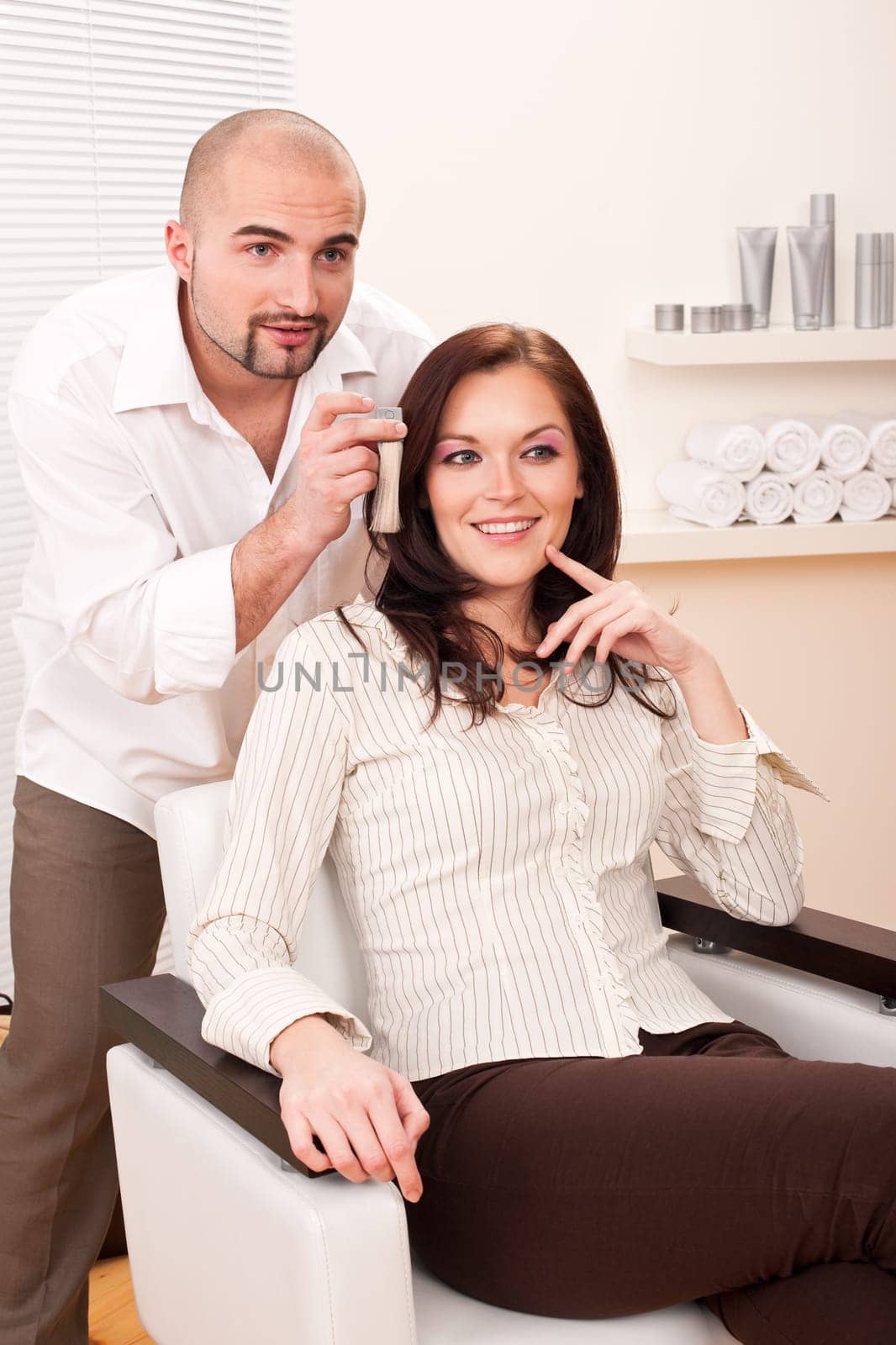 Professional male hairdresser choose hair dye color at modern salon, female customer change hair color