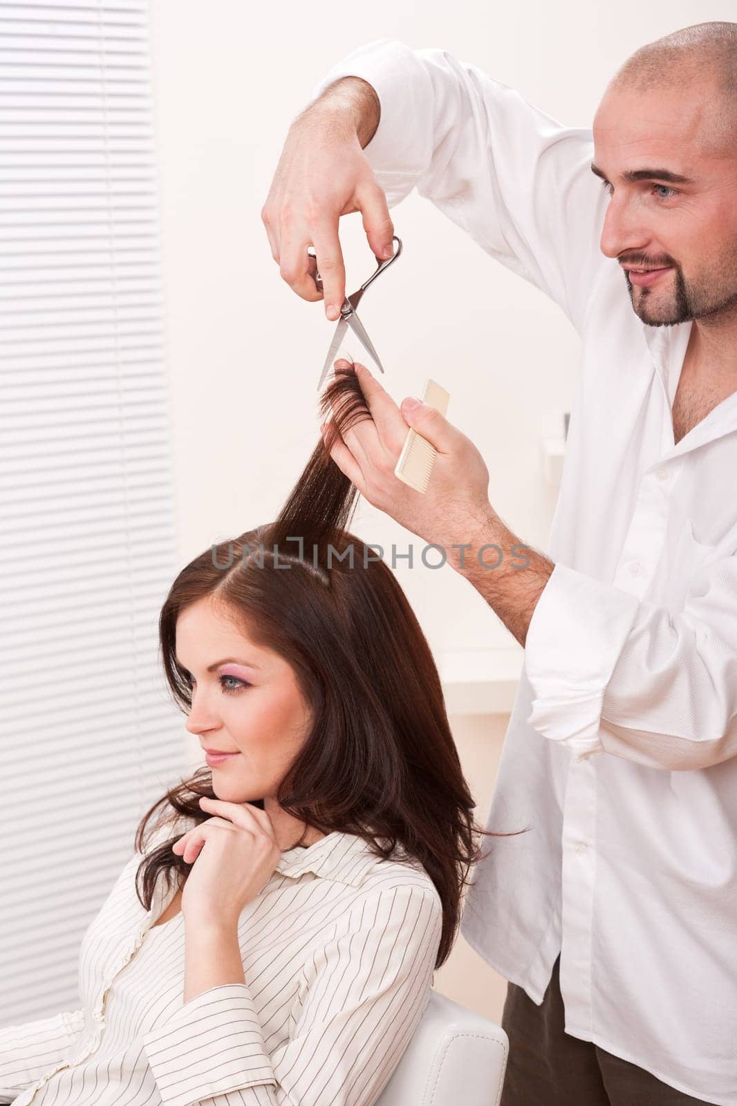 Professional male hairdresser cut with scissors at salon, customer getting new haircut