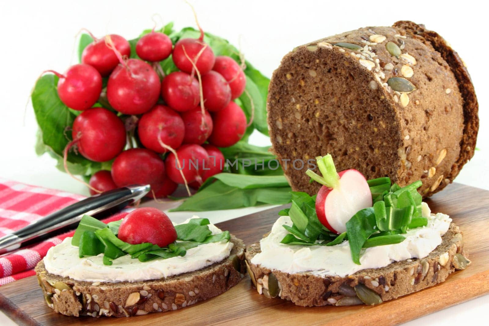 a slice of bread topped with cream cheese and fresh wild garlic