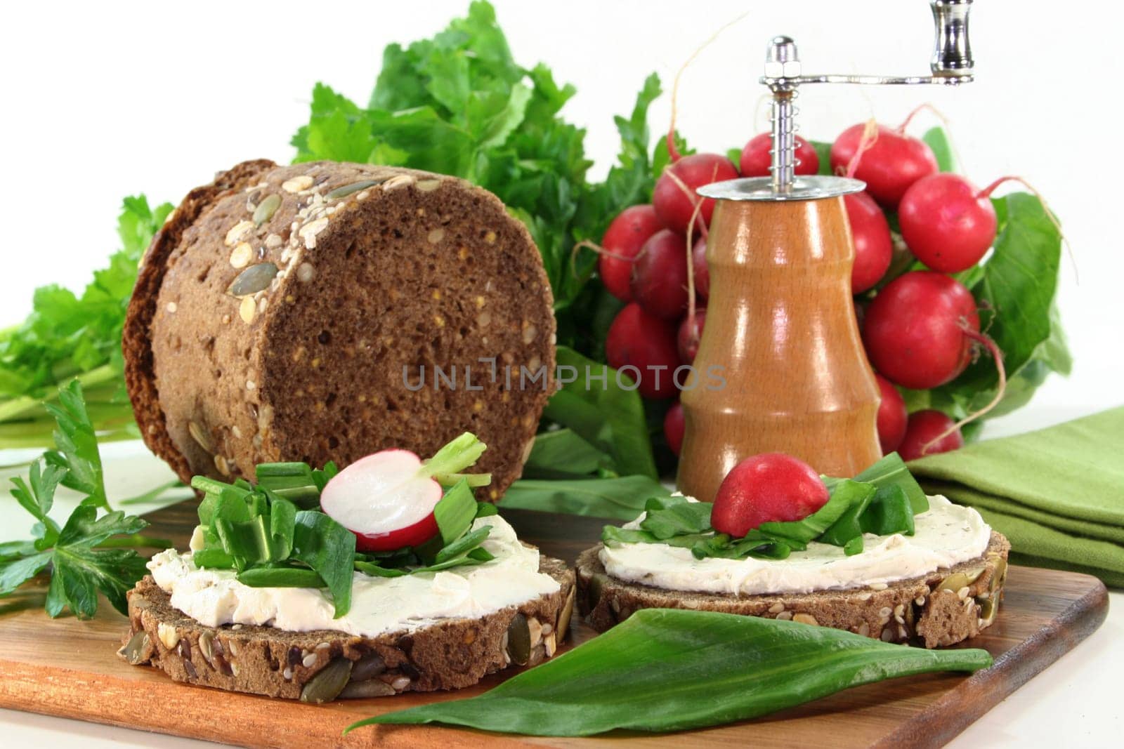 a slice of bread topped with cream cheese and fresh wild garlic