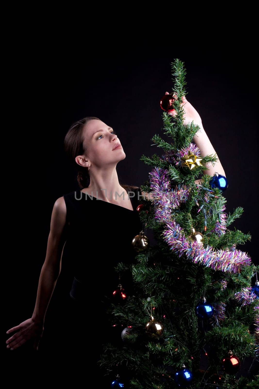 Young beauty woman decorate christmas tree with balls