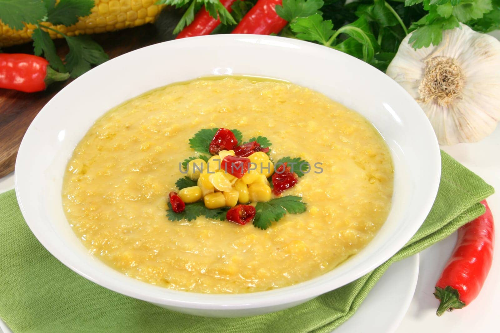 a bowl of corn soup with chili and coriander