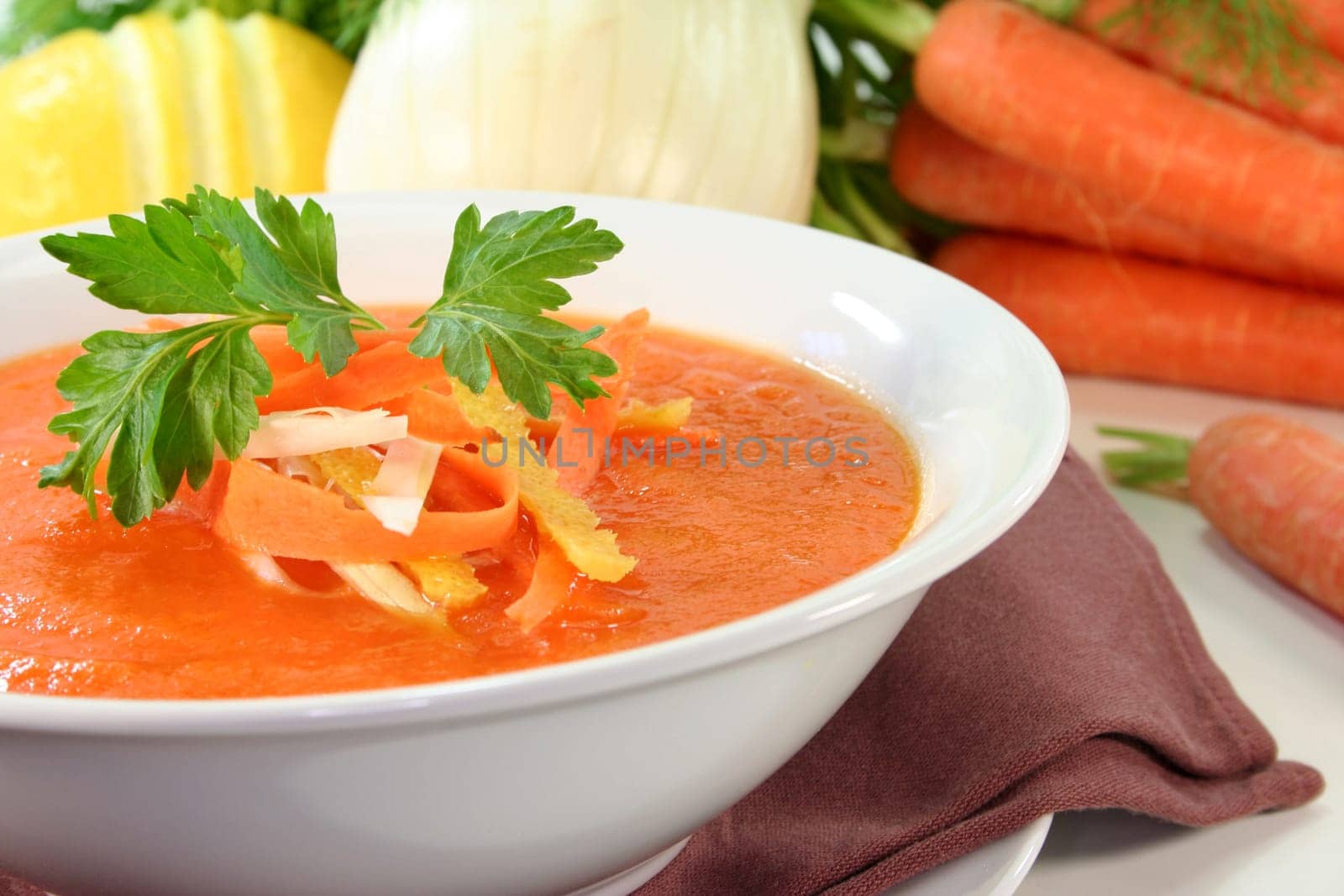a bowl of carrot soup with fennel and lemon
