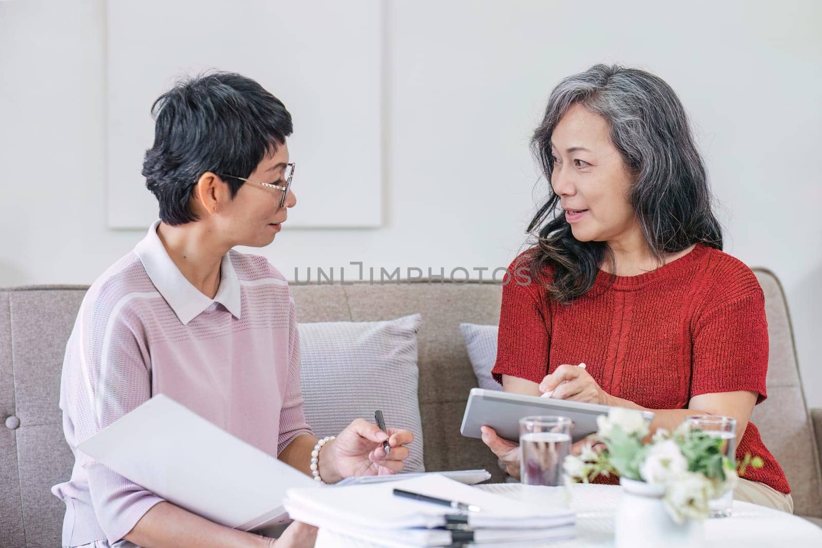 Senior woman planning future life insurance and finance happily in the living room..