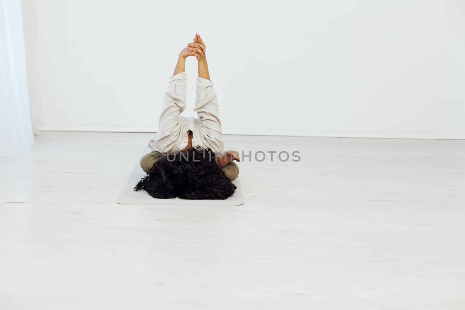 workout in the studio woman doing exercises yoga asana shavasana lotus pose by Simakov
