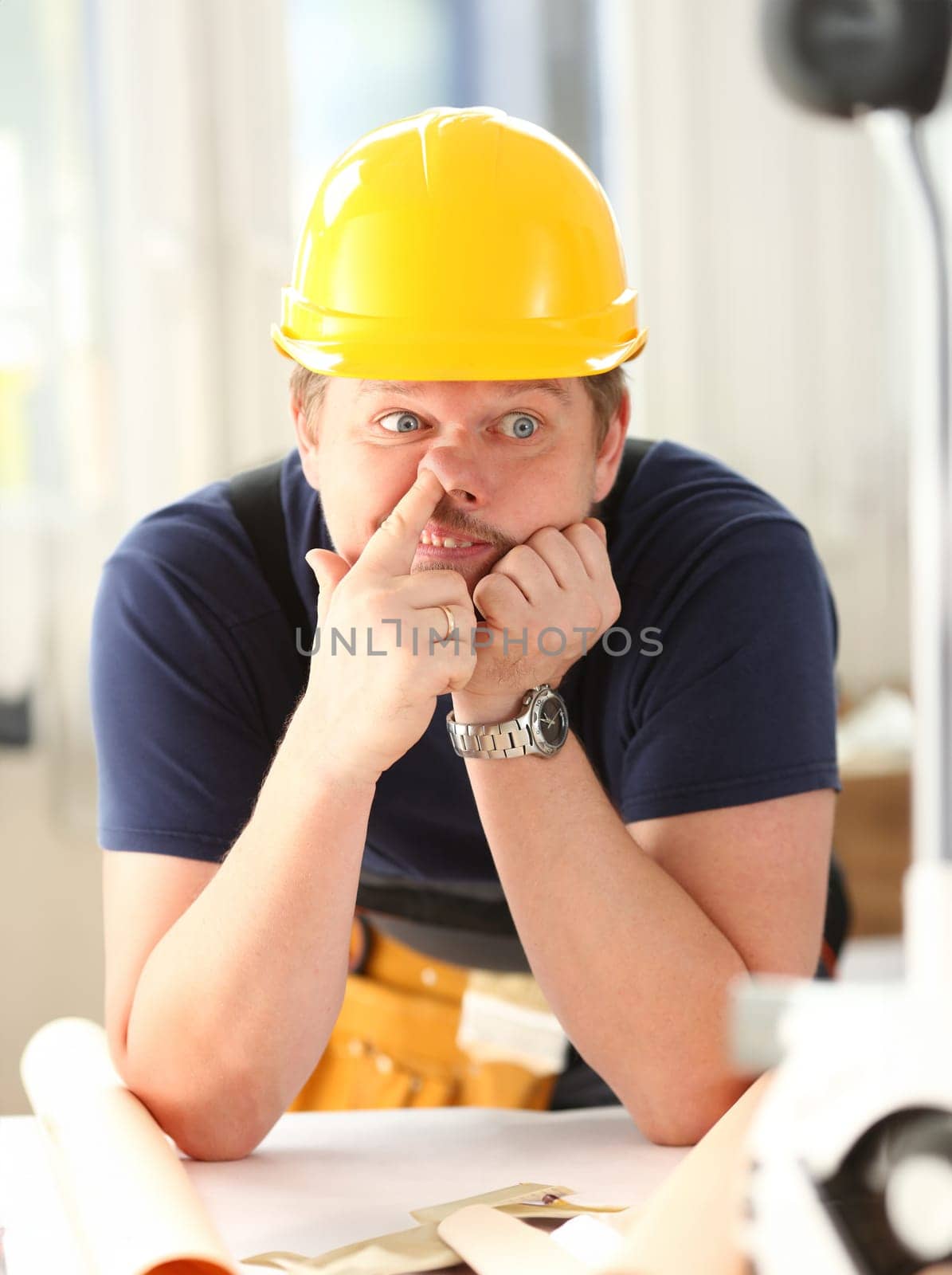 Smiling funny worker in yellow helmet posing with finger in nose. Manual job workplace DIY inspiration improvement fix shop hard hat joinery startup idea industrial education profession career