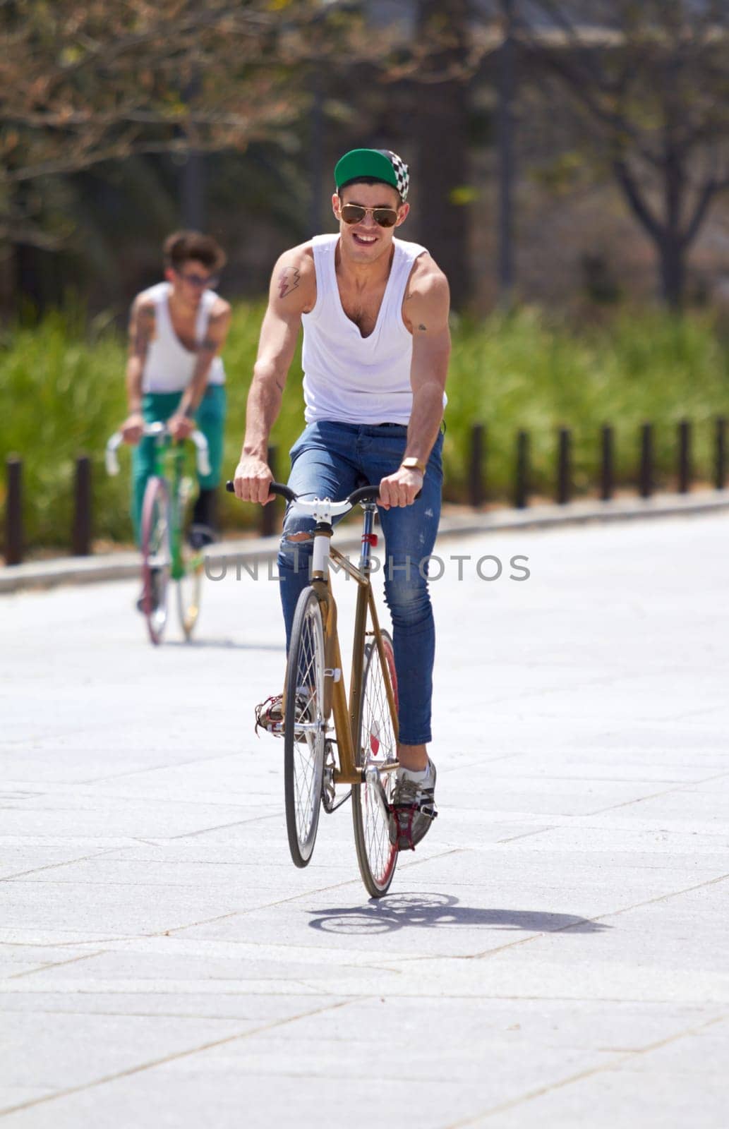 Men, summer and students in street, bicycle and sustainable transport for sunshine, freedom and wheelie. Young gen z people, retro bike and outdoor together in road for travel, university or campus.