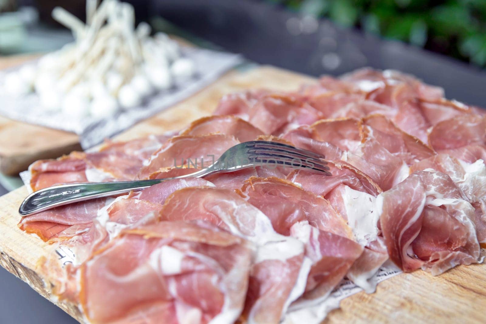 Thin slices of raw ham on wooden cutting board, Appetizers. parties. events.