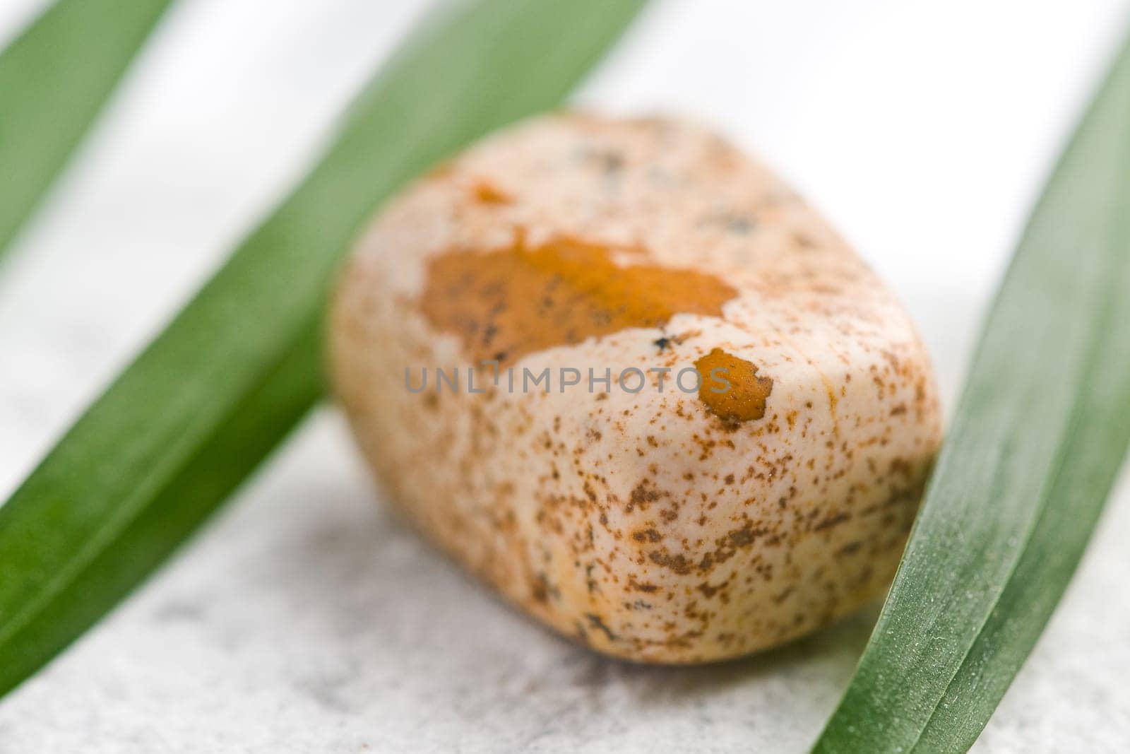 Natural stone jasper shines in beautiful colors on a white background
