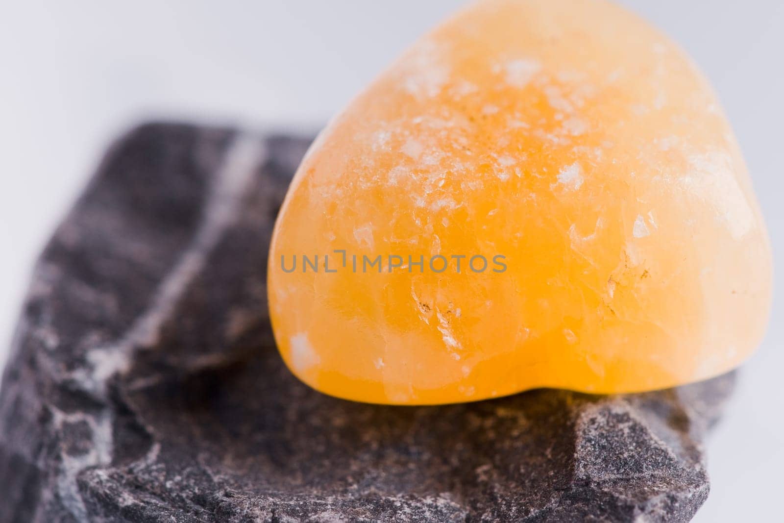 Natural stone carnelian shines in beautiful colors on a white background