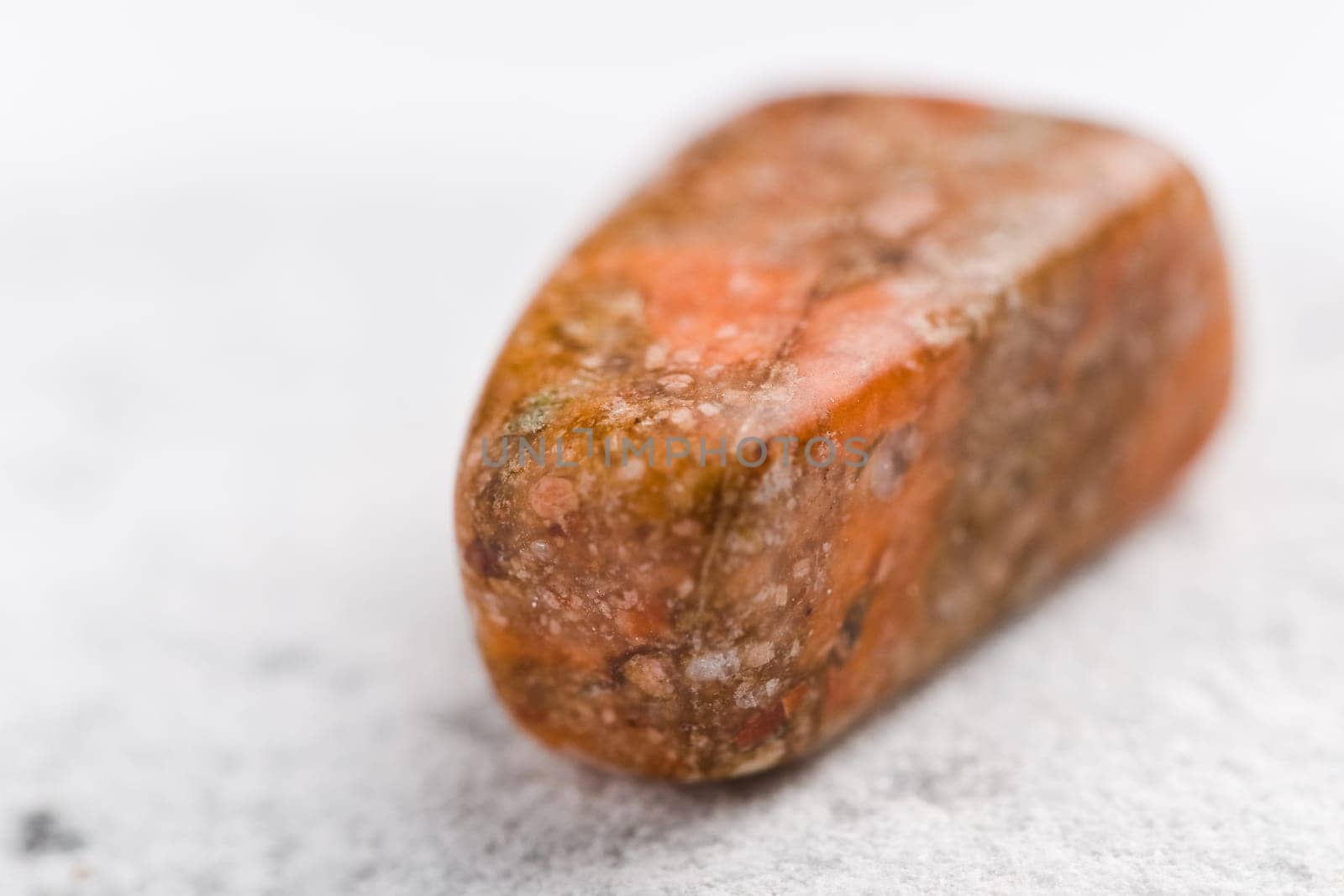 Natural stone unakite shines in beautiful colors on a white background