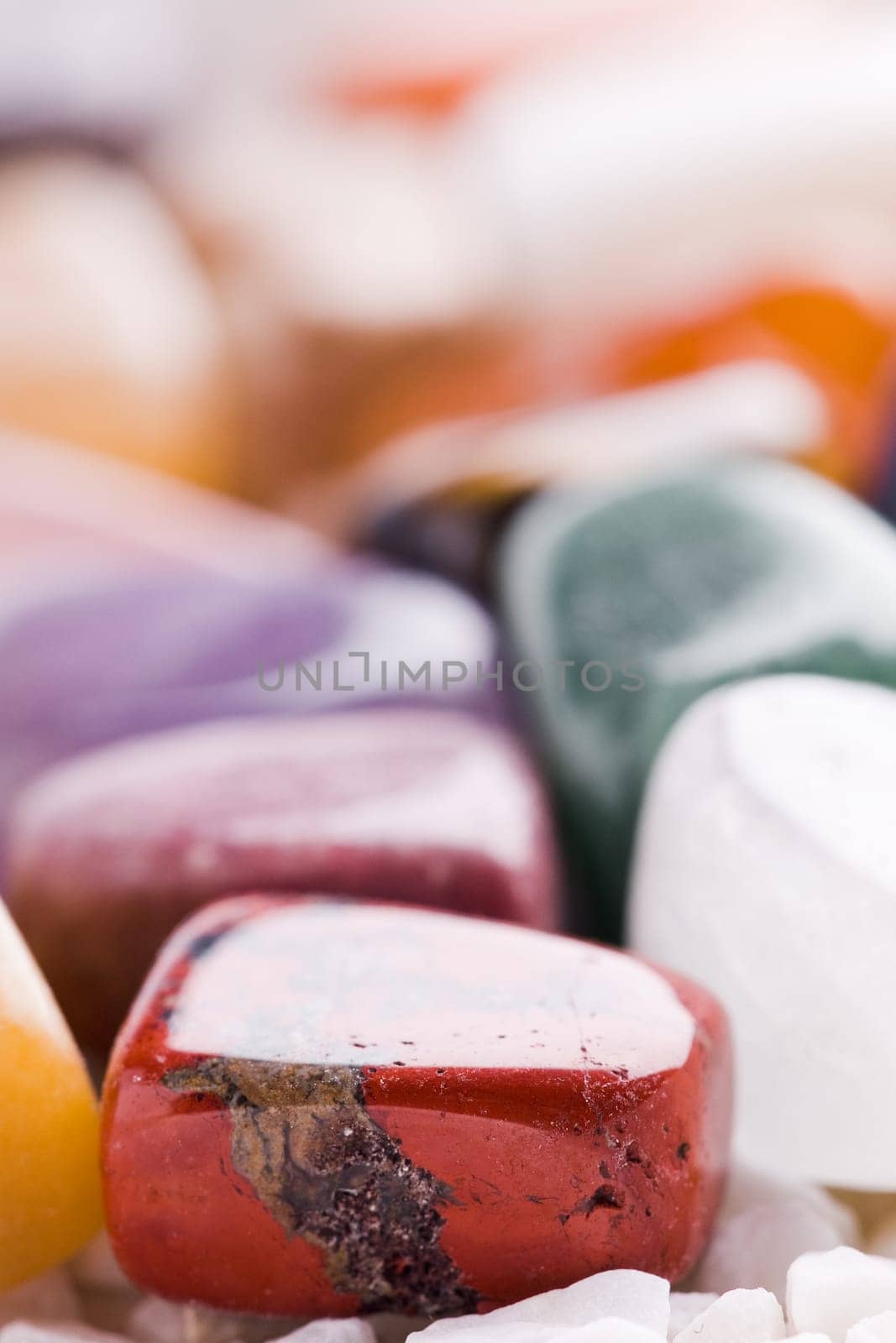 Many different natural stones in beautiful colours on a white background