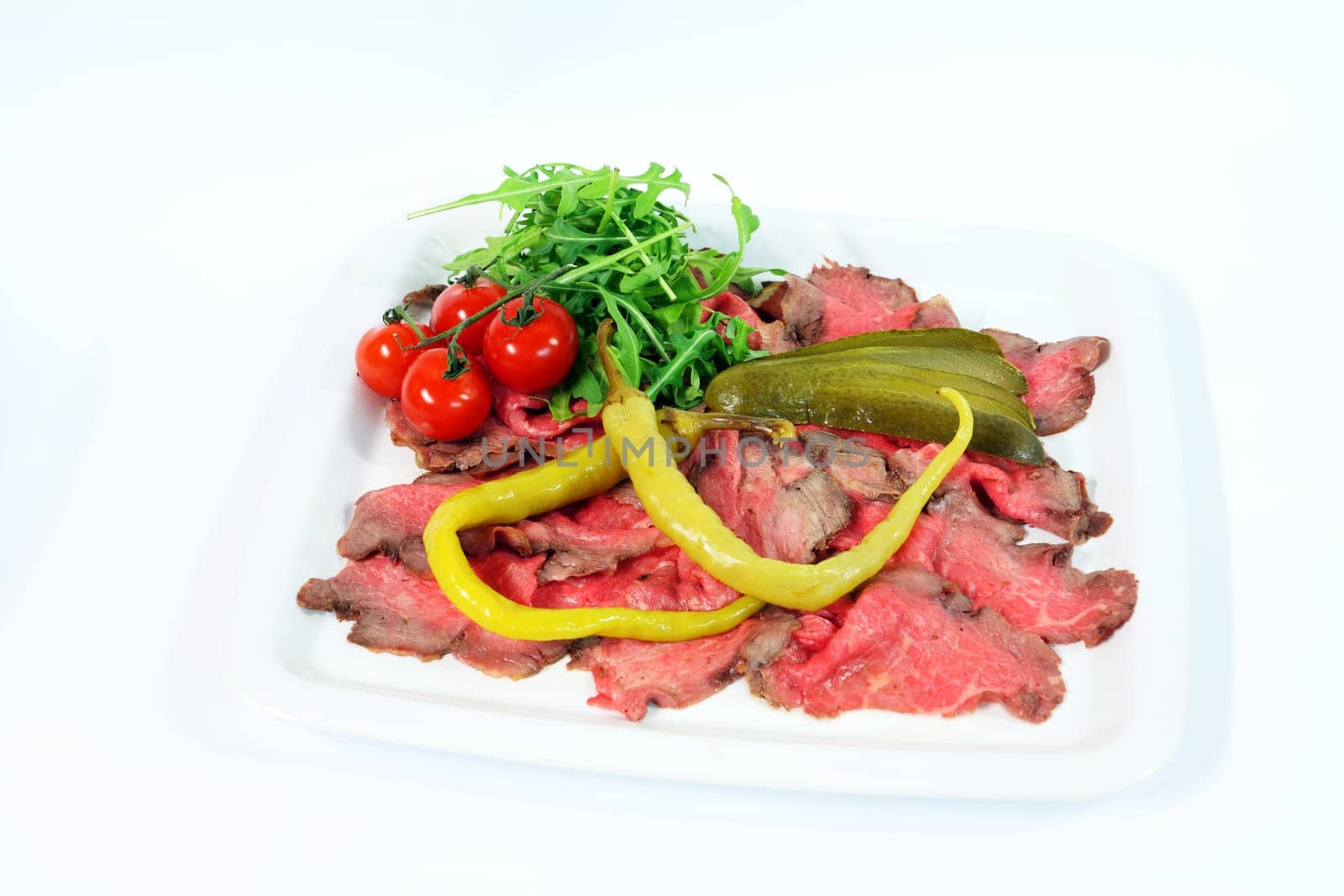 Roastbeef with gherkin and hot pepper on white background