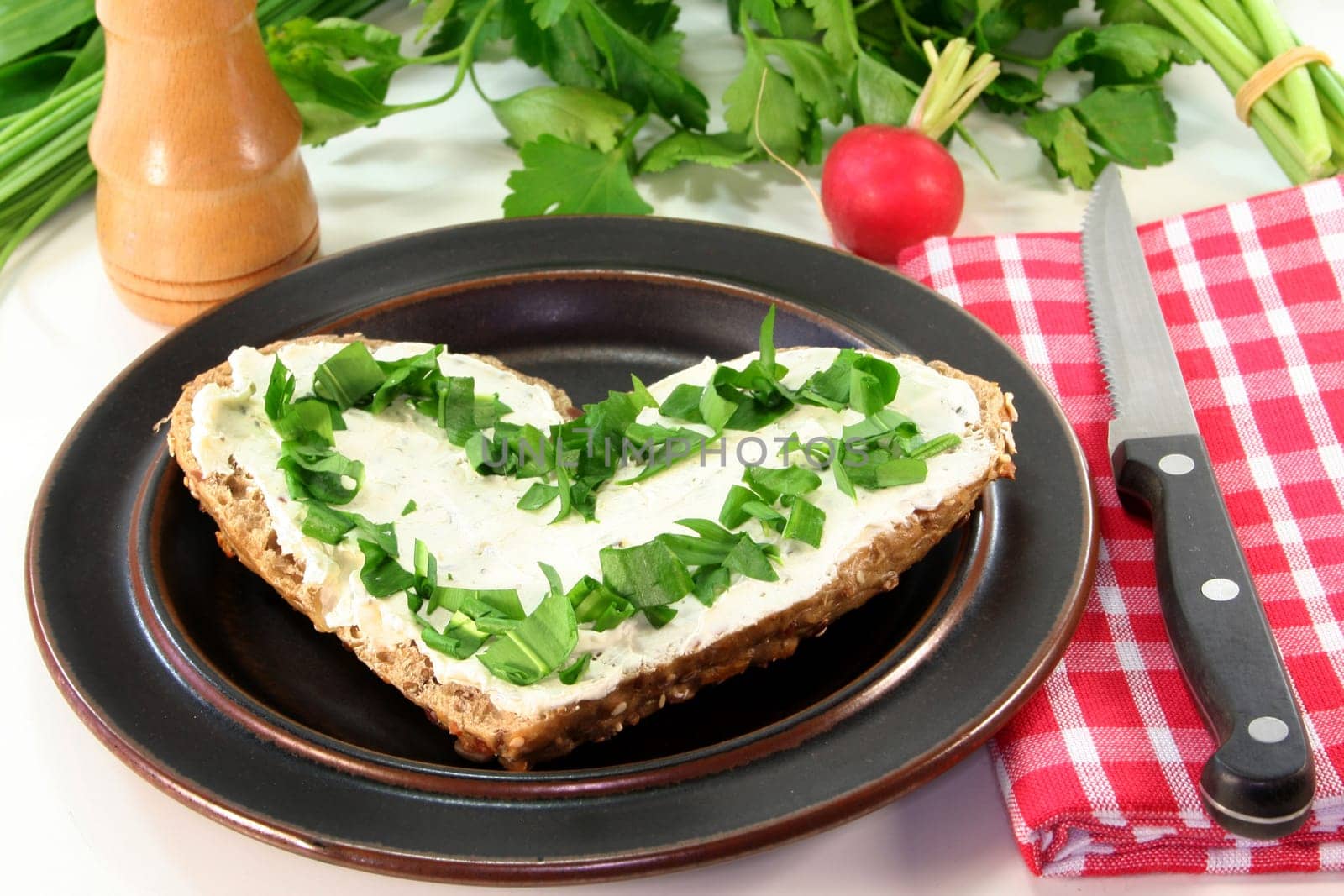 a roll topped with cream cheese and fresh wild garlic