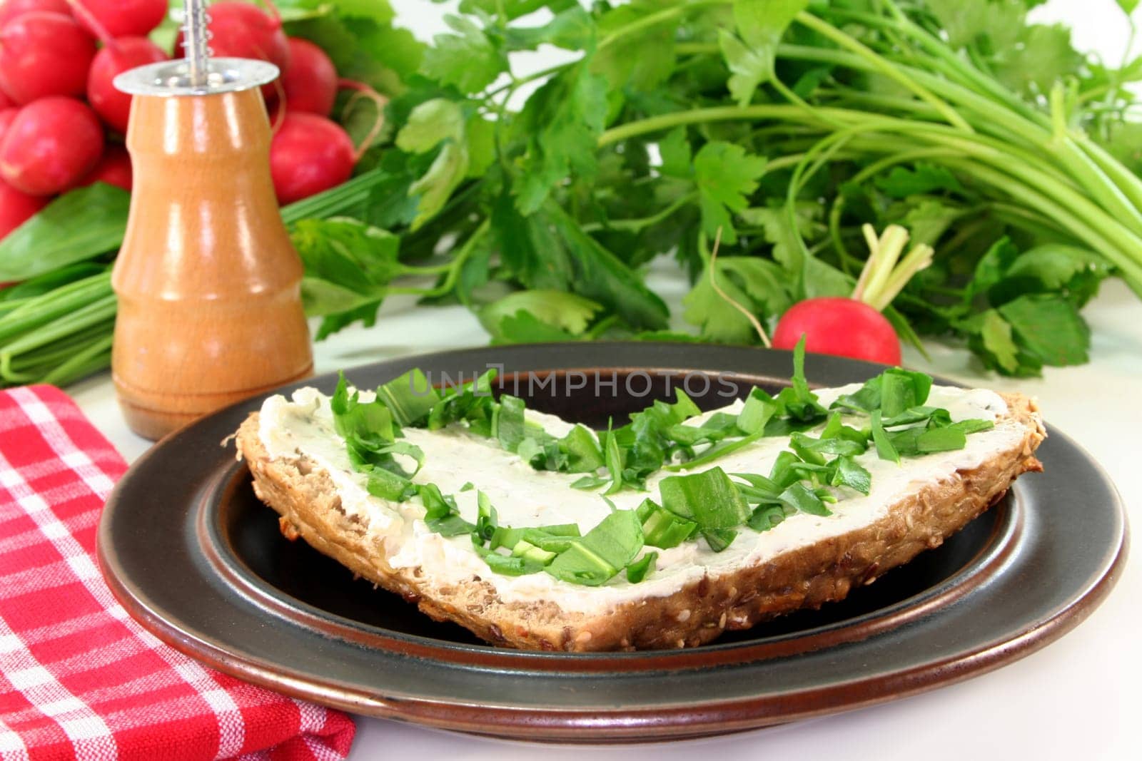a roll topped with cream cheese and fresh wild garlic