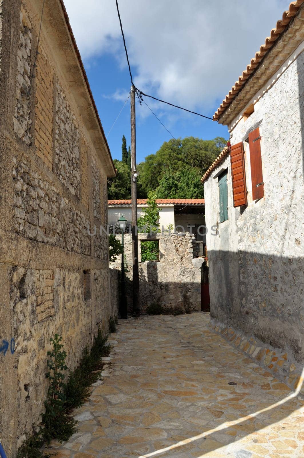 Narrow street and traditional houses in village Louha in the island of Zakynthos, Greece.