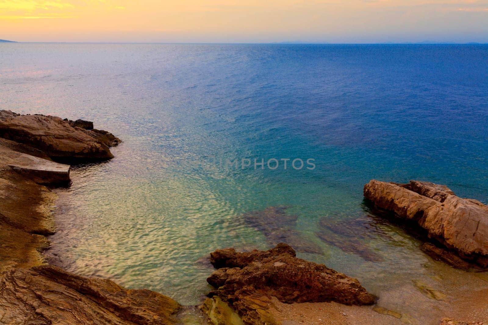 Image of the colorful water of the Adriatic sea against the rocky coastline