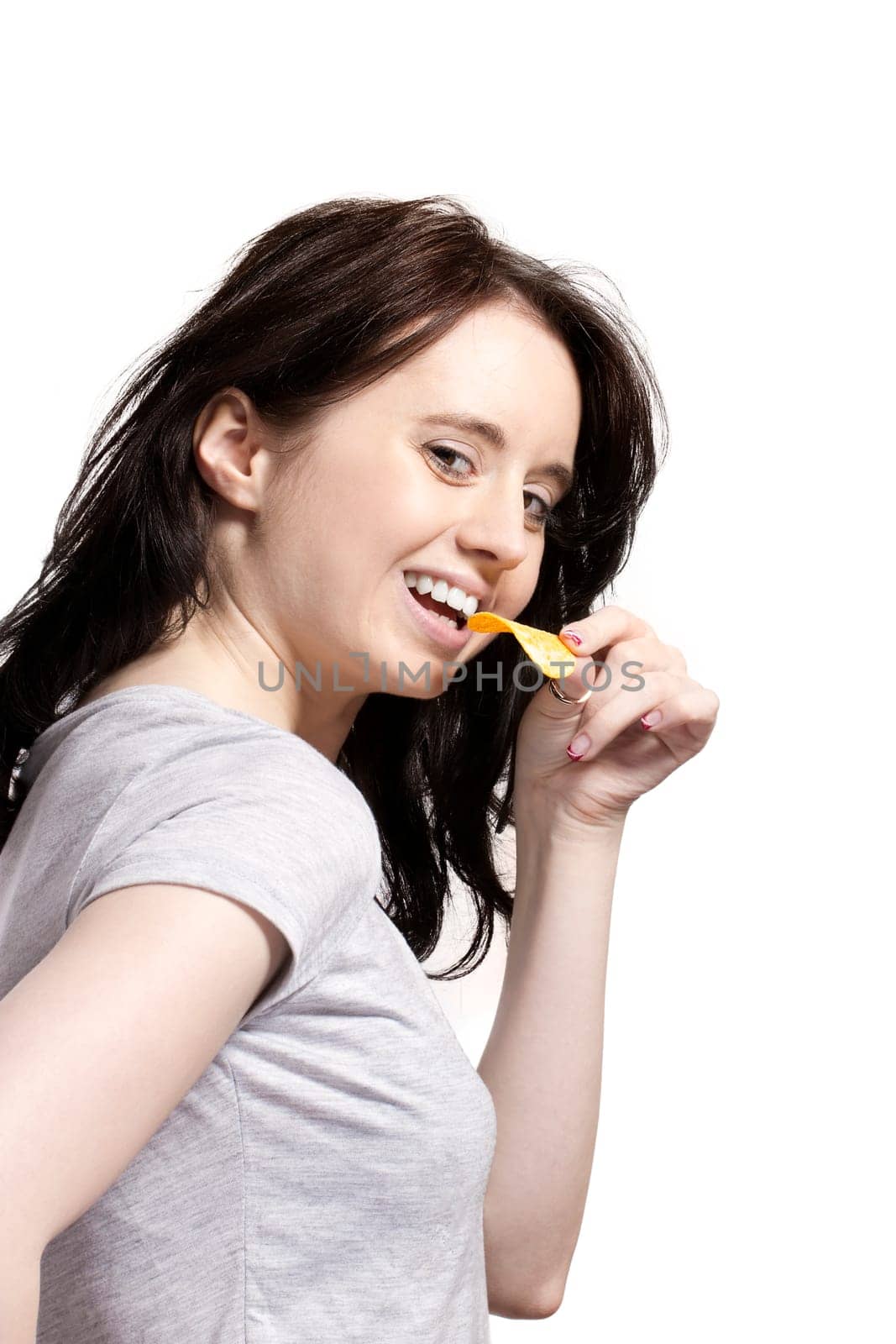 Young laughing woman nibbling on potato chip