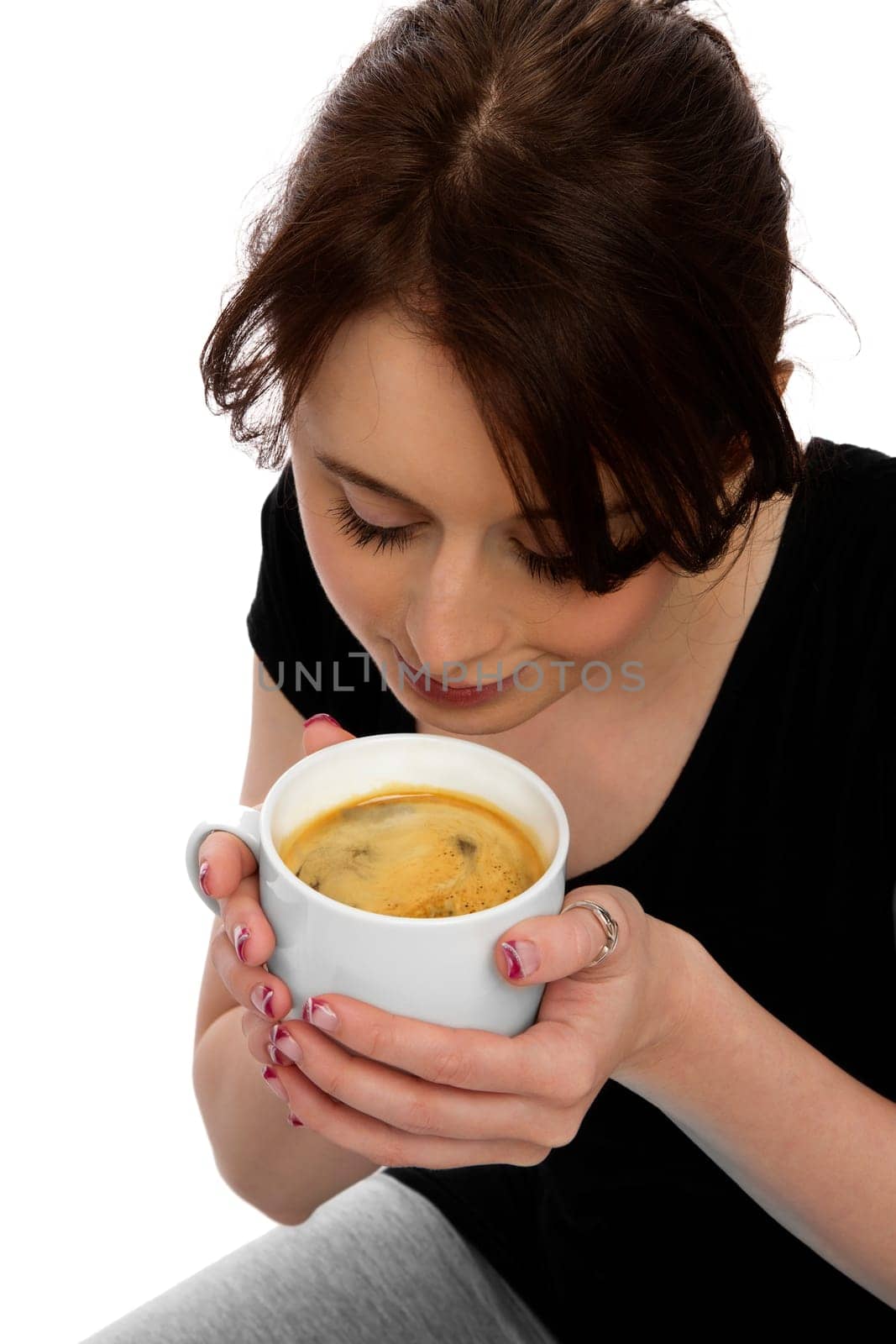Young pretty woman holding coffee cup and smelling coffee