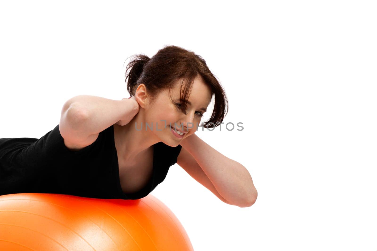 Young pretty woman exercising with an orange exercise ball