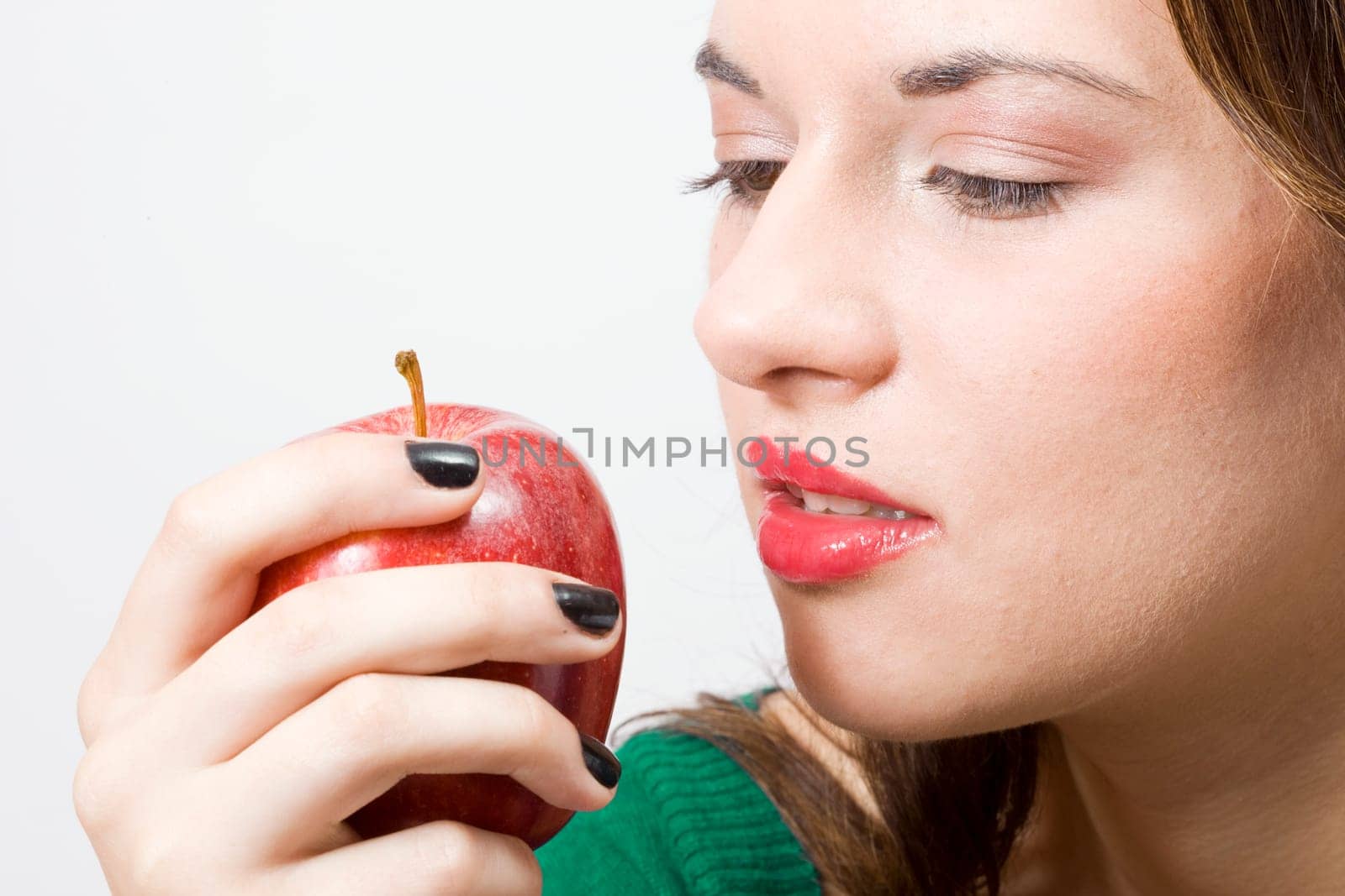 a young pretty girl eating a fresh healthy red apple