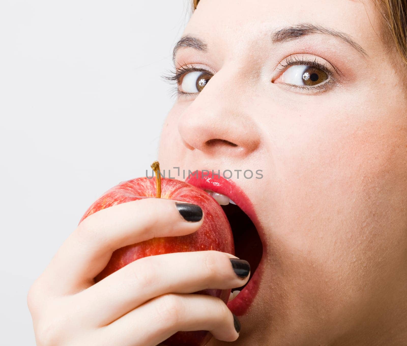 a young pretty girl eating a fresh healthy red apple