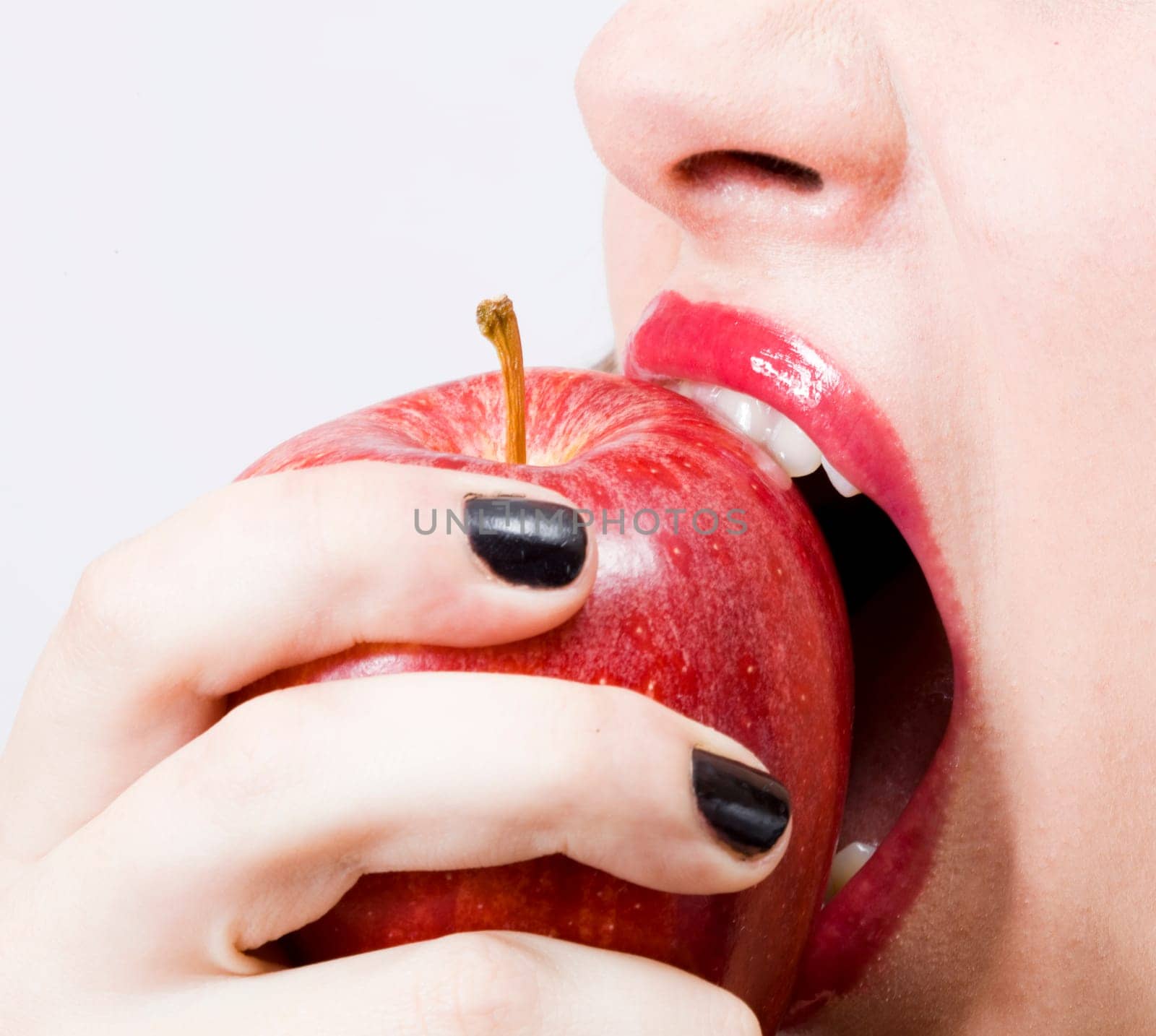 a young pretty girl eating a fresh healthy red apple