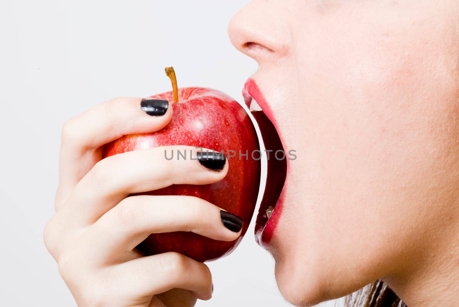 a young pretty girl eating a fresh healthy red apple