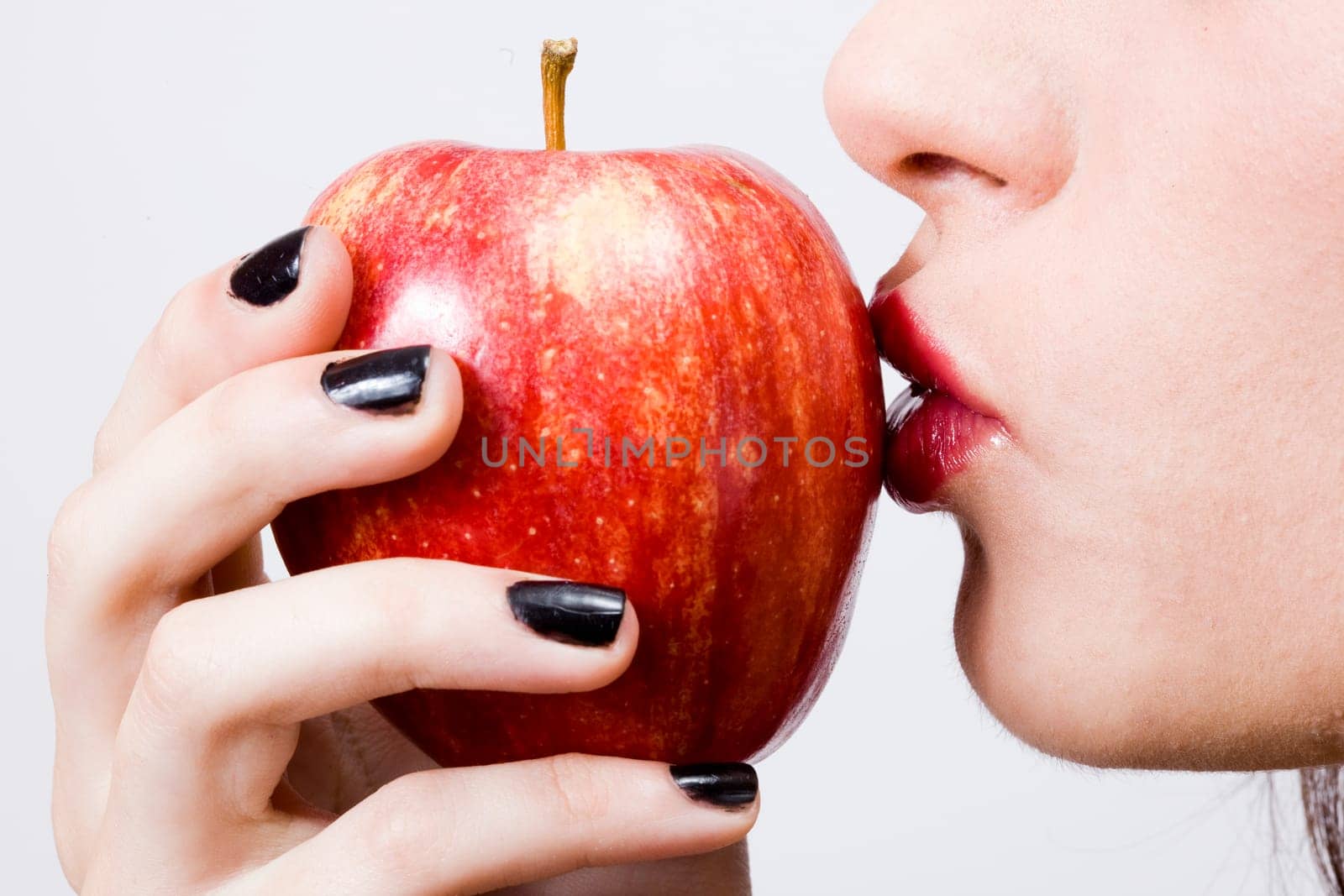 a young pretty girl eating a fresh healthy red apple